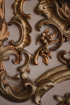 Intricate close-up of ornate baroque design with bronze and gold elements, highlighting artistic craftsmanship.