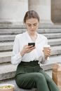Woman in White Long Sleeve Shirt Holding White Disposable Cup