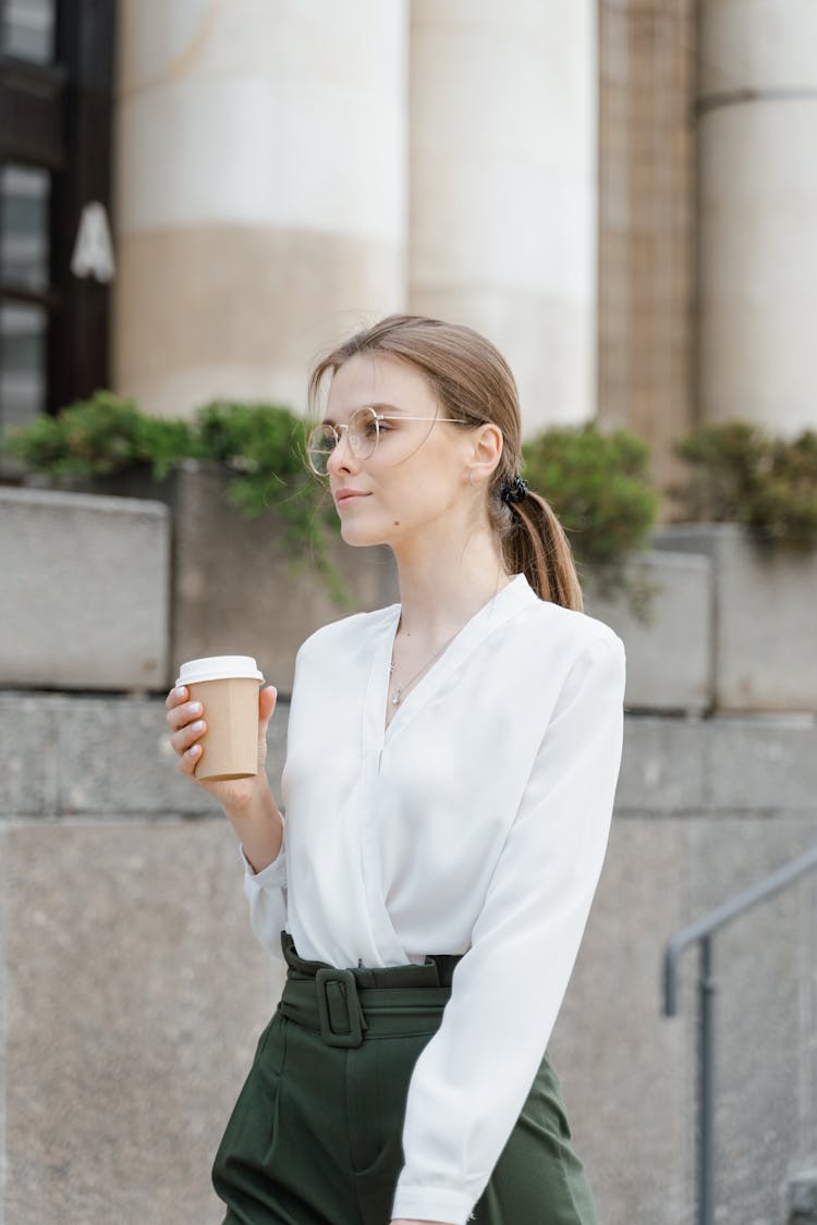 Photograph Of A Woman With Eyeglasses Holding A Disposable Cup