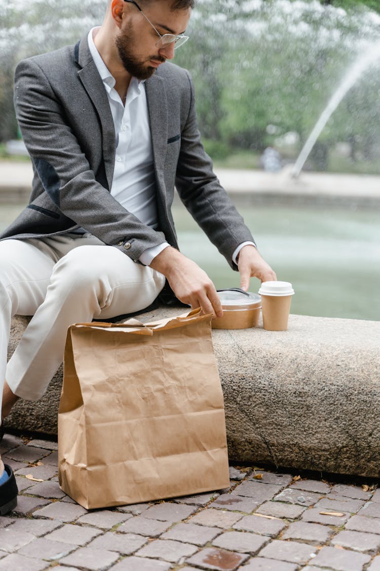 
A Bearded Man In A Suit Having Takeaway Food