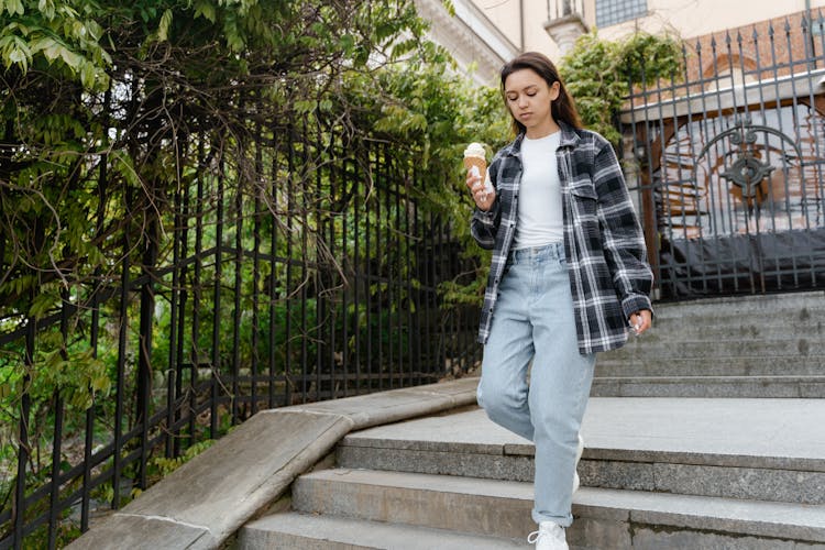 Woman Walking On Concrete Stairs Holding Ice Cream Cone