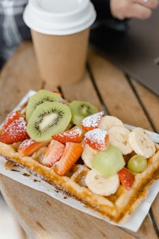 Crispy waffle with fresh fruit served outdoors, perfect for a tasty breakfast.