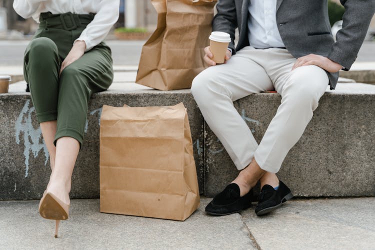 A Man And Woman Sitting On The Concrete Bench