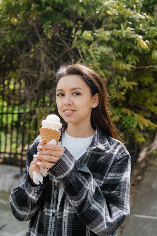 Woman wearing Checkered Dress Shirt holding an Ice Cream 