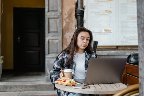 Woman in Checkered Dress Shirt using Grey Laptop 