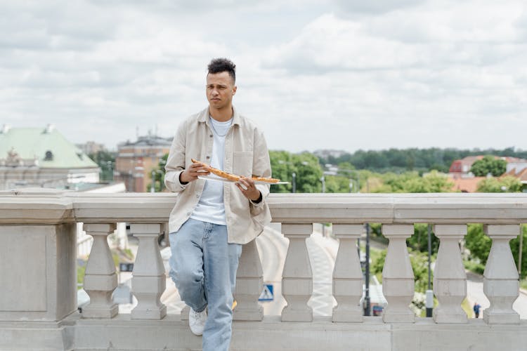 Man Holding A Long Bread