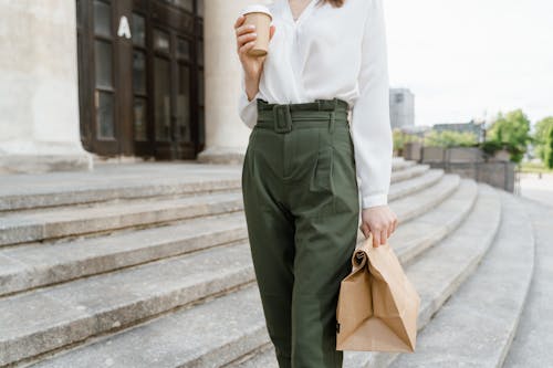 Woman Holding a Cup and Her Takeaway Paper Bag