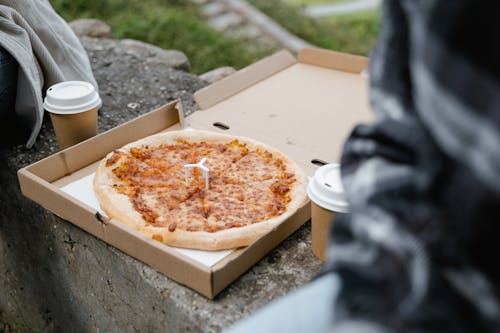 Close Up Photo of a Whole Pizza and Cups of Coffee