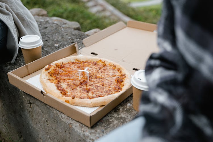 Close Up Photo Of A Whole Pizza And Cups Of Coffee