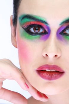 Close-up portrait showcasing vibrant makeup highlighting eyes and lips in a studio setting.