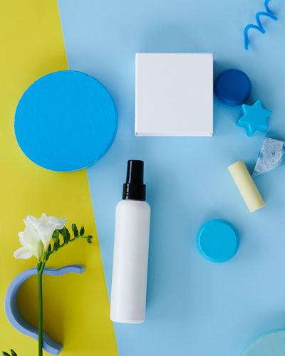 Publicité spray parmi des formes géométriques colorées, format carré