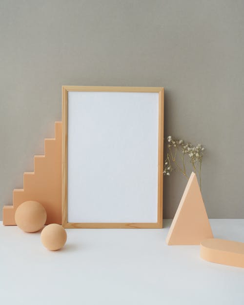
A Wooden Picture Frame Leaning on a Gray Wall