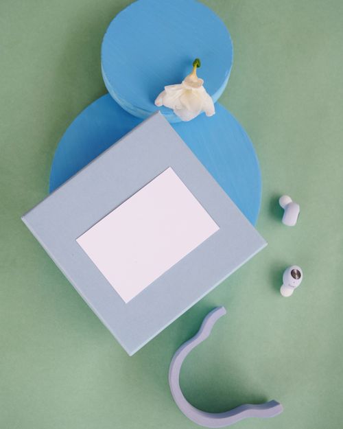 Free Creative composition with wireless earbuds on blue and green background, ideal for tech mockups. Stock Photo