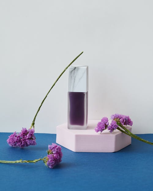 Foto stok gratis botol parfum, bunga ungu, fotografi produk
