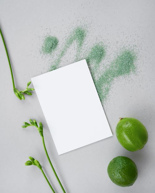 Sheet of Paper next to Two Limes 
