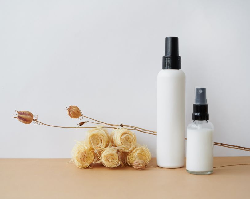 Minimalist cosmetic bottle design with natural elements like dried flowers