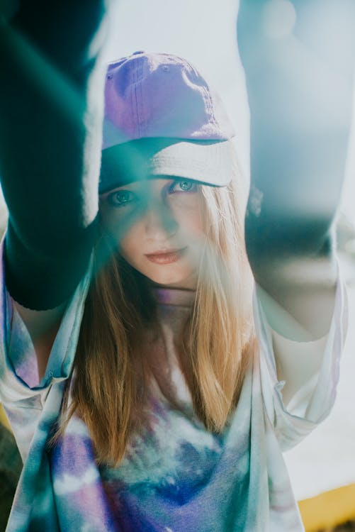 A Woman Wearing a Cap and a Tie Dye Shirt