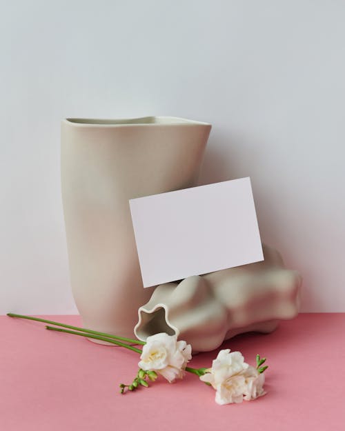 Blank Paper Sheet Next to Vases and Flowers 
