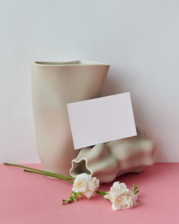 Blank Paper Sheet Next To Vases And Flowers 