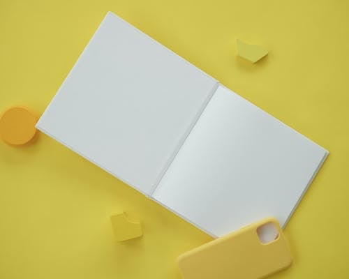 
A Blank Open Book on a Yellow Surface
