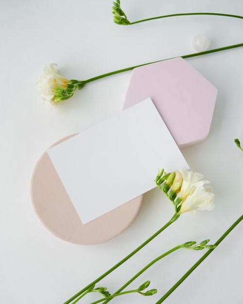 Free A minimalist mockup featuring white paper with freesia flowers, perfect for elegant design presentations. Stock Photo