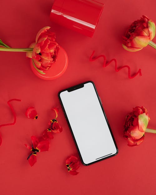A Smartphone Beside Red Roses