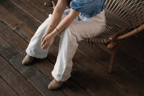 Free Crop woman sitting on chair in studio Stock Photo