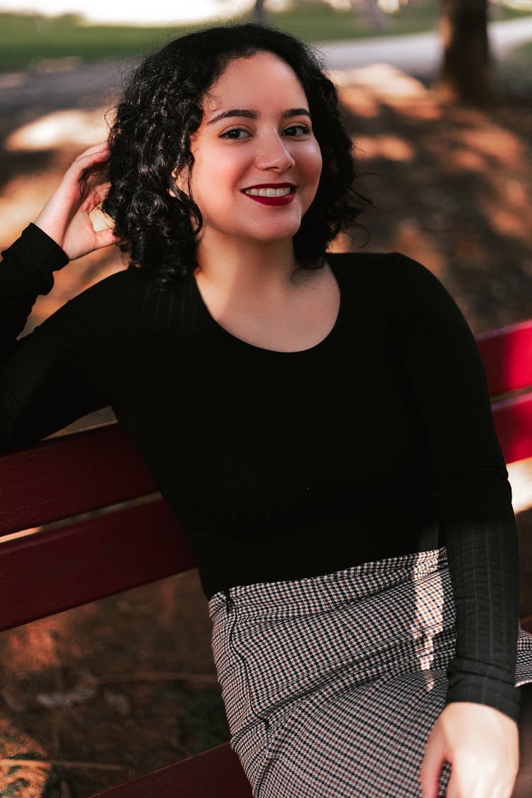 Woman In Black Long Sleeve Shirt Sitting On Wooden Bench