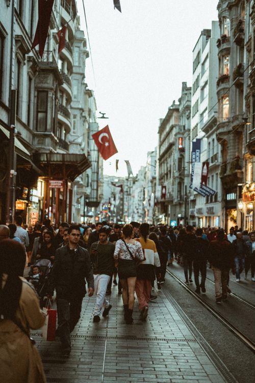 Free Crowded Istiklal Street in Istanbul with people walking under Turkish flags at dusk. Stock Photo