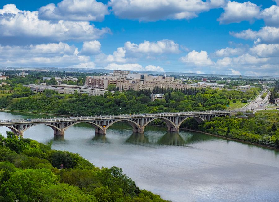 Aerial view of University Bridge in Saskatoon, surrounded by lush greenery.