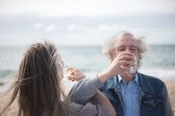 Woman in Blue Vest and Gray Shirt Smoking Cigarette