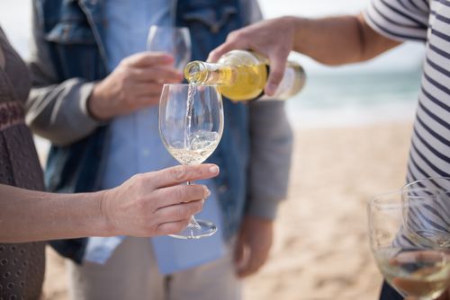 Free A bottle of white wine being poured into glasses during a beach gathering in Portugal. Stock Photo