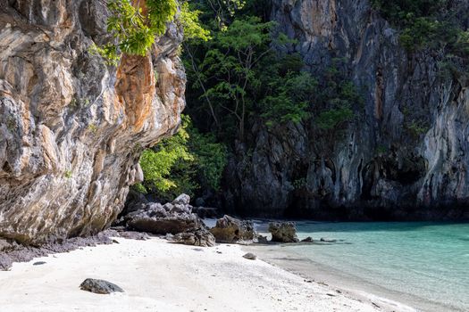 Serene beach with stunning limestone cliffs and clear turquoise water in Thailand.