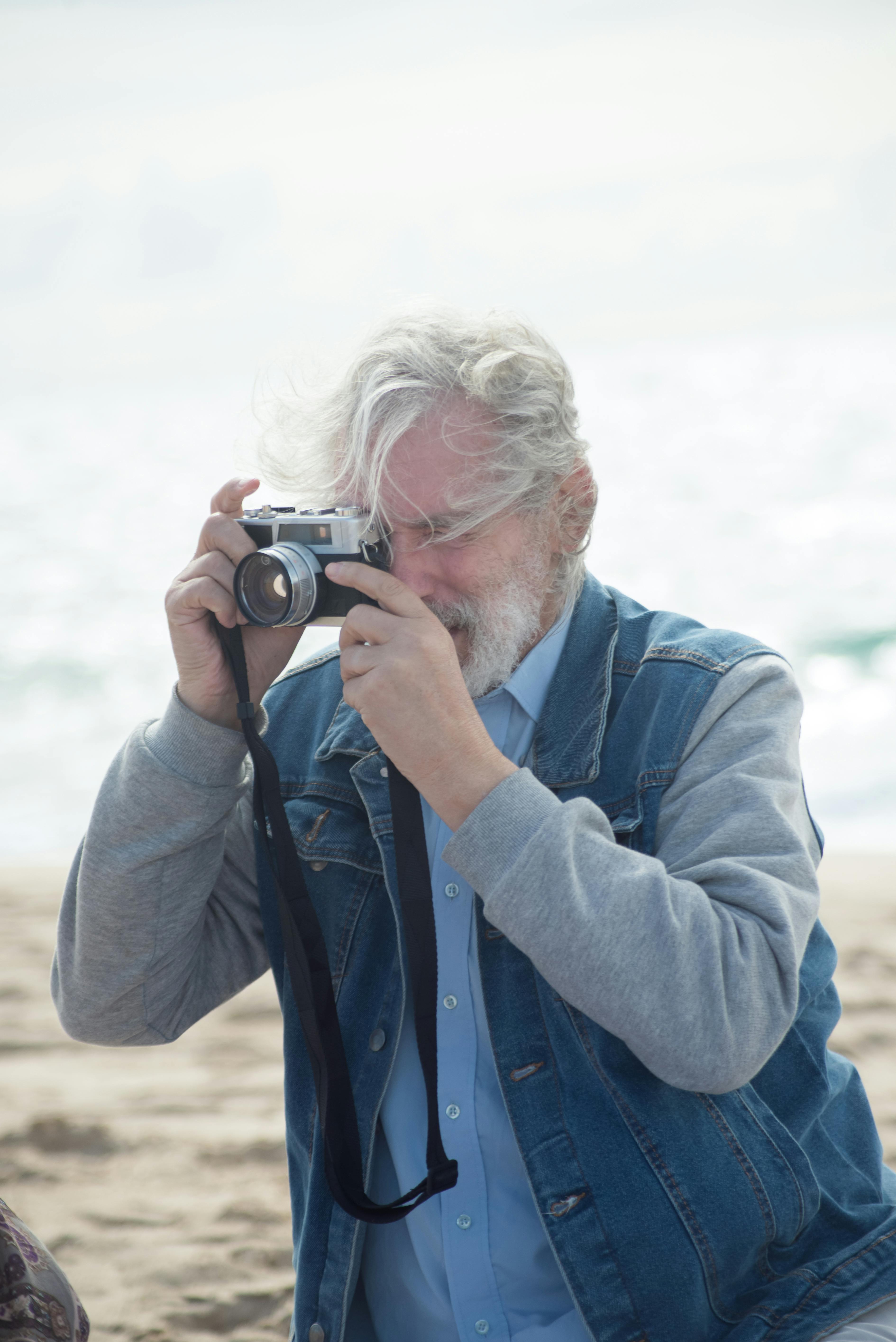 man in denim jacket talking pictures with a camera