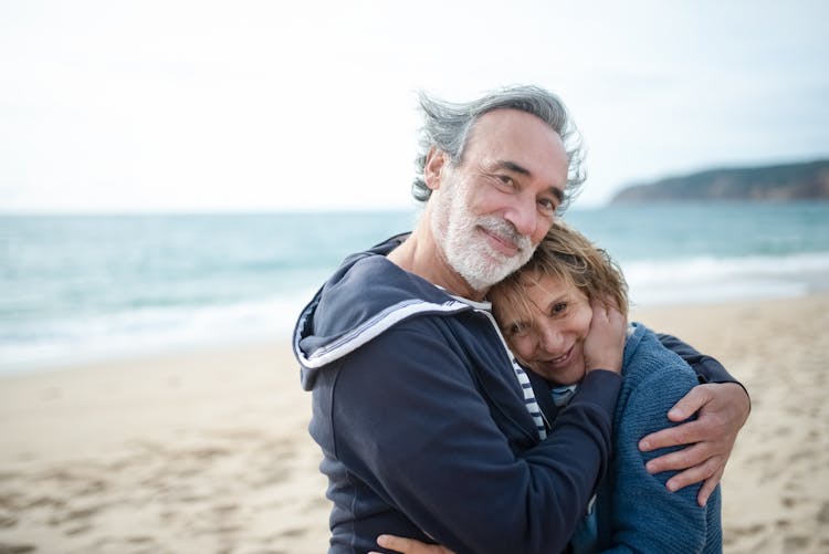 Mature Couple Embracing At The Beach 