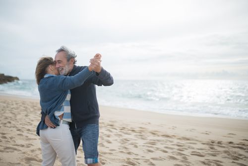 Free Happy couple dancing on a serene beach in Portugal, embracing love and nature. Stock Photo