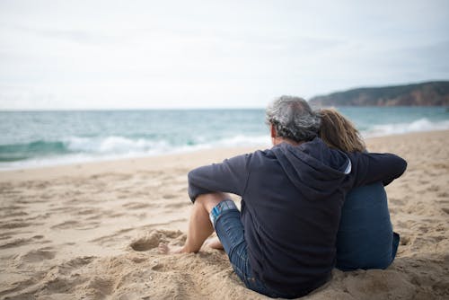 Free Elderly Couple Sitting On Seashore Stock Photo