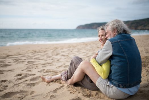 Senior couple cherishing moments together on a serene beach in Portugal.