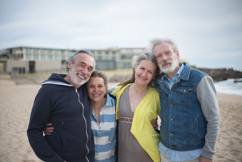 Free A cheerful group of mature friends enjoying a day at the beach in Portugal, showcasing togetherness. Stock Photo