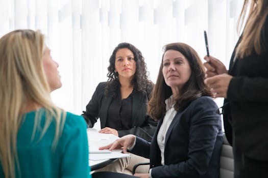 Women engaged in a collaborative business meeting indoors with natural light.