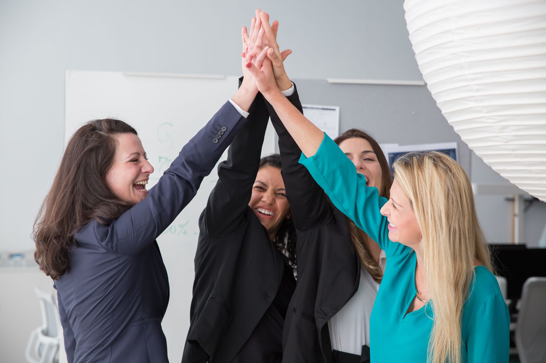 Group of enthusiastic businesswomen achieving a success with a high five.