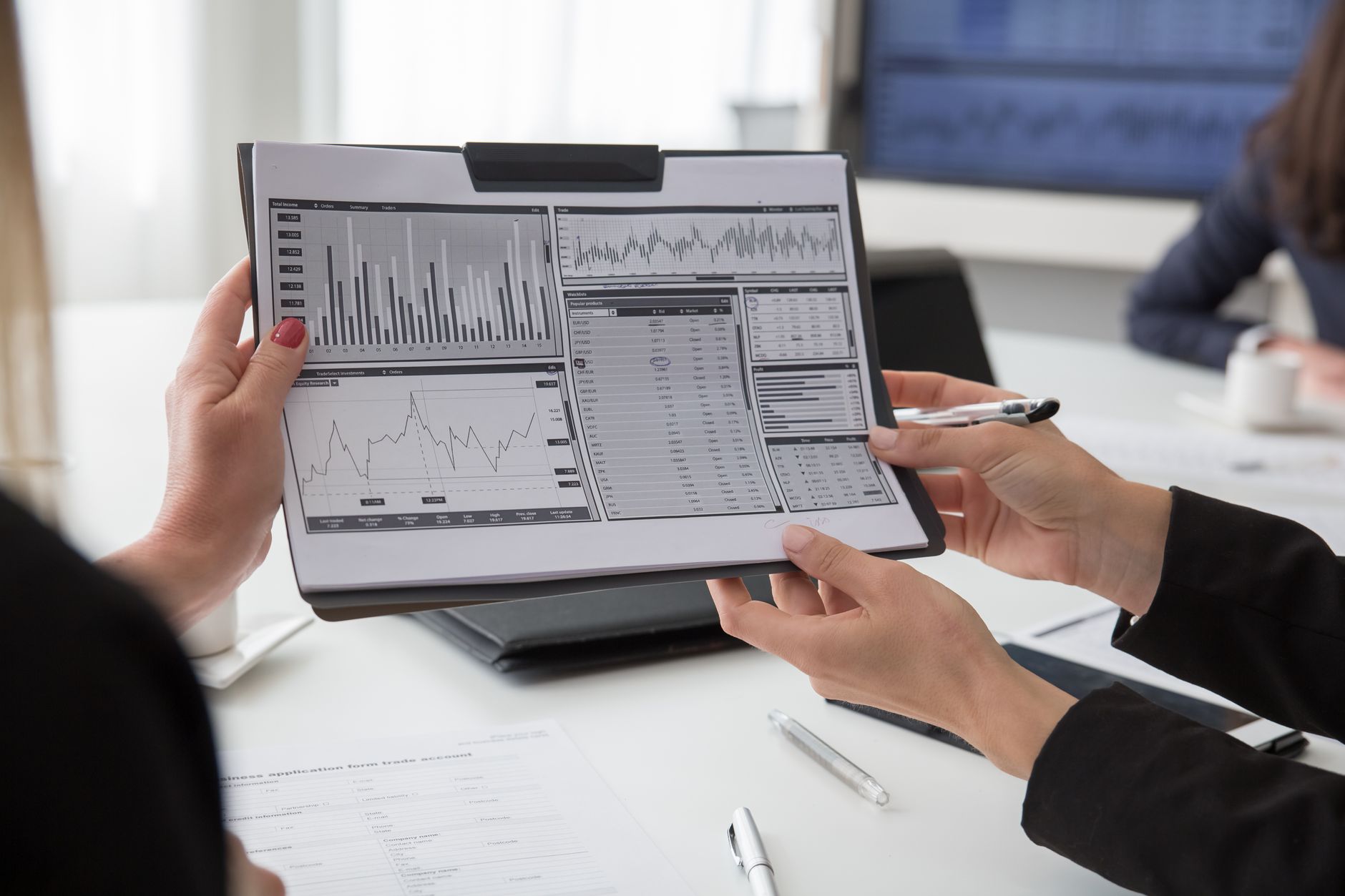 Professionals reviewing exposure charts and lending documents during a risk meeting.