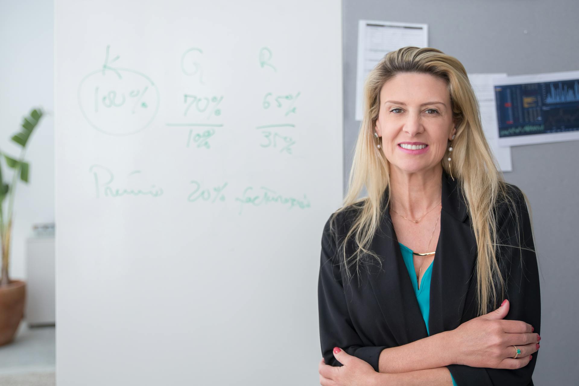 Woman in Corporate Attire Smiling near a White Board