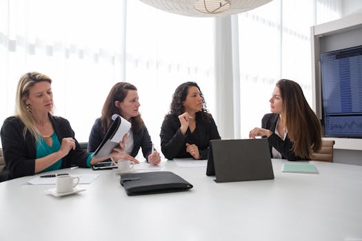 Businesswomen discussing strategies in a modern conference room setting. Teamwork in action.
