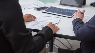 Primer plano de profesionales revisando documentos en oficina, sobre posesión efectiva online Chile