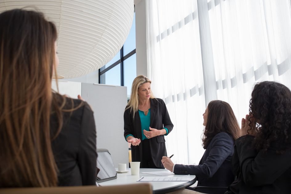 A recruiter leads a collaborative hiring discussion with team members in a bright modern office