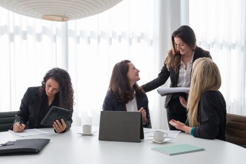 Free Business meeting with women in corporate attire engaged in discussion and planning indoors. Stock Photo