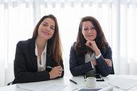 Woman in Black Blazer Sitting at the Table