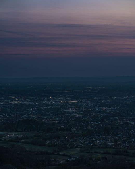 A serene aerial cityscape view of Cheltenham, England at dusk.