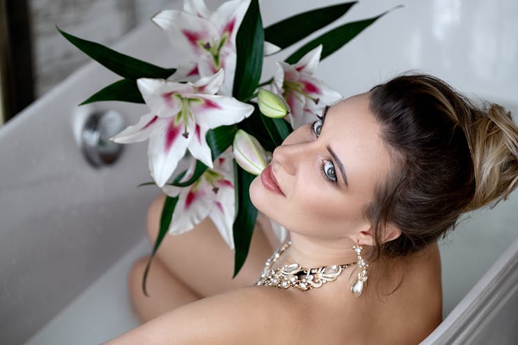 A Woman Holding A Bouquet Of Lilies